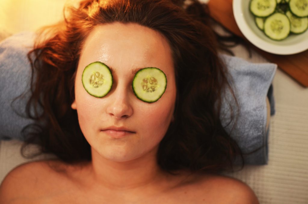 woman relaxing with cucumbers over her eyes.