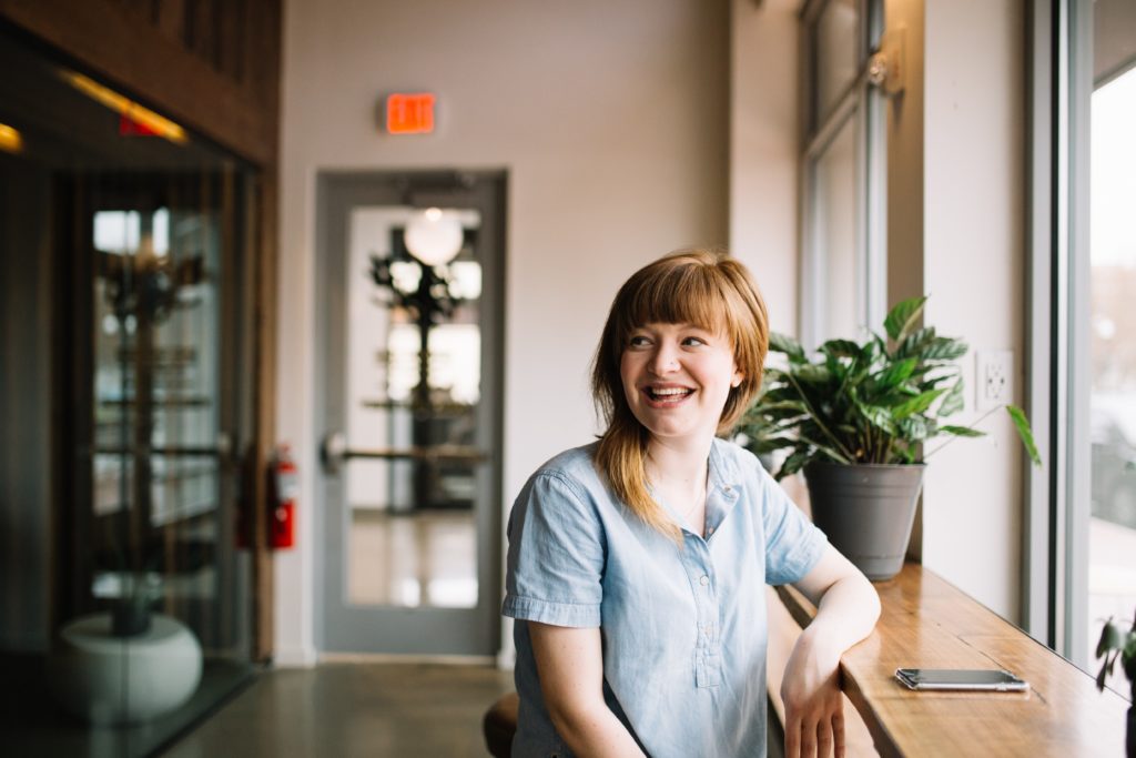 woman sitting in a coffee shop smiling 