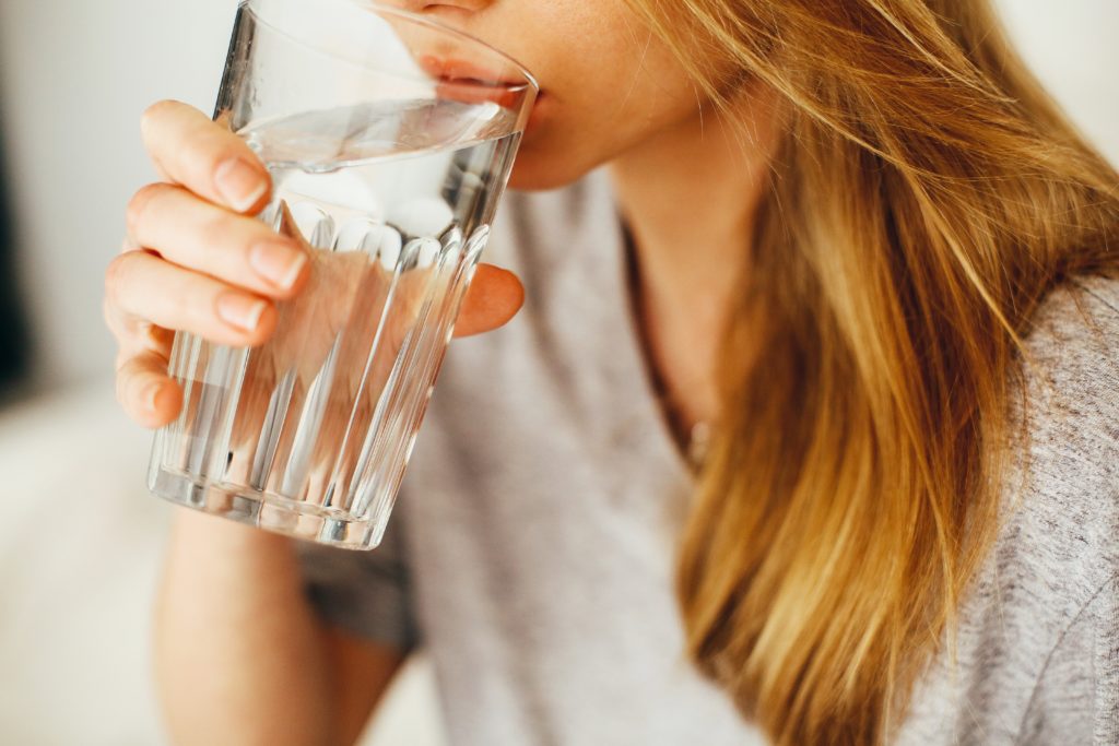 woman drinking a large glass of water