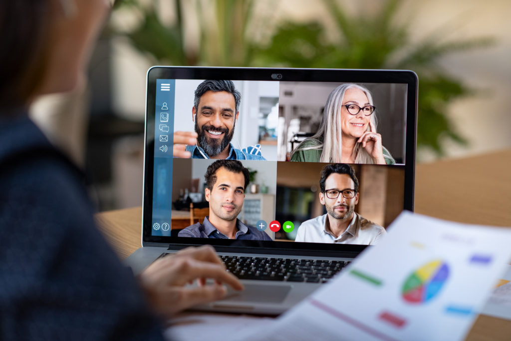 woman talking with coworkers on a video conference in her home