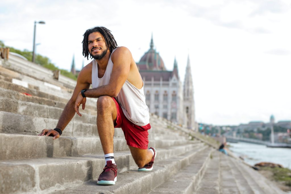 man stretching on stairs outside before run
